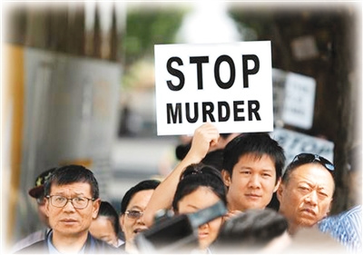 参与游行的华侨华人手举“停止谋杀”、“停止强奸”等标语。（人民网记者王欲然摄）