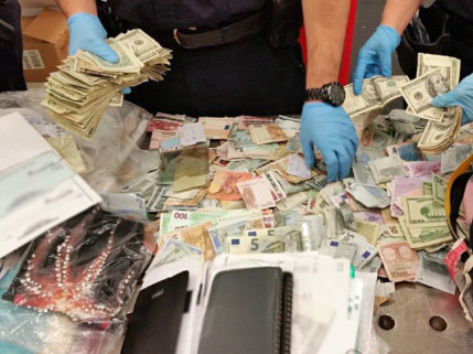 海关及边境保护局(CBP)每年出动嗅钱犬,“抓”捕携带超额现金出入境的旅客,成绩斐然。图为P嗅钱犬“闻”出旅客携带大笔现钞后被查扣情形。(CBP提供)