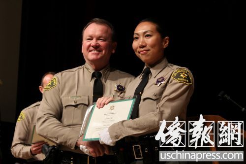 麦唐纳局长向石玉娜办法毕业证书。(美国《侨报》/高睿