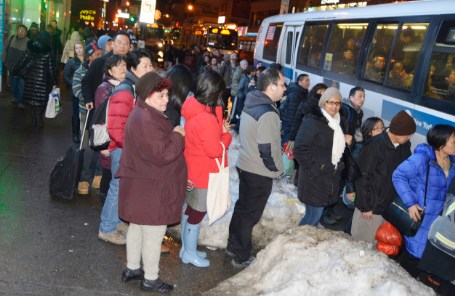 积雪太多阻碍交通,法拉盛公交被挤爆,乘客等一个多小时仍坐不上车。(美国《世界日报》/俞姝含