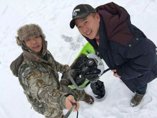 明州钓友享受户外冰钓乐趣,也号召更多同好加入,图为钓友们正在钻冰洞。(美国《世界日报》)