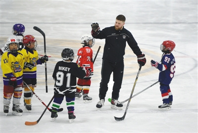 3月25日晚上，来自加拿大多伦多3A冰球队沃恩国王队的主教练马特（右二）给北京小狼俱乐部的小孩上了一堂训练课。