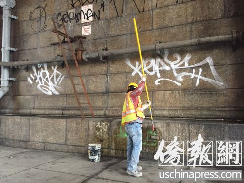 交通局清洁工人在清洗华埠曼哈顿桥下的涂鸦。(林菁/摄)