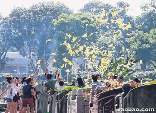 明天是清明节，一些公众提早前往蔡厝港华人坟场拜祭亲人，上坟时依习俗撒冥纸。（林国明摄）