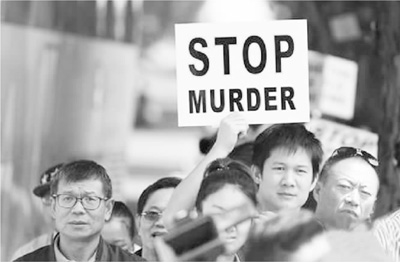 2015年12月15日，参与游行的华侨华人手举“停止谋杀”标语。王欲然摄