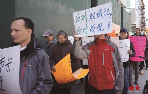参与示威民众高举中文抗议标语。(美国《侨报》/陈辰