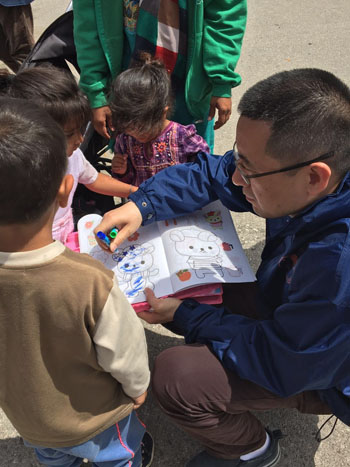希腊华人志愿者团队的队员细心辅导孩子们画画。（《欧洲时报》/苏珊娜