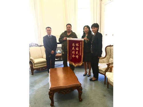 曹华钦(左2)、何林涛(左1)代表该区居民,将“体贴民情、为民请命”的锦旗交到了领事部主任陆青江参赞(右2)和一等秘书王原(右1)的手中。(《欧洲时报》/孔帆