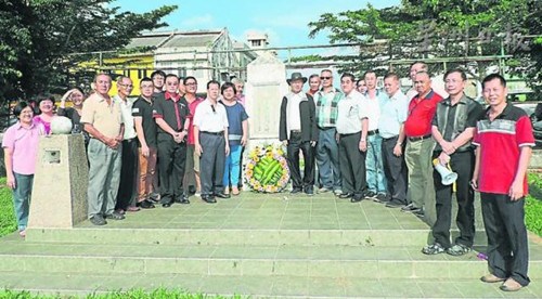 献花仪式后，全体淡属华团领袖和出席者在纪念碑前大合照。（马来西亚《星洲日报》）