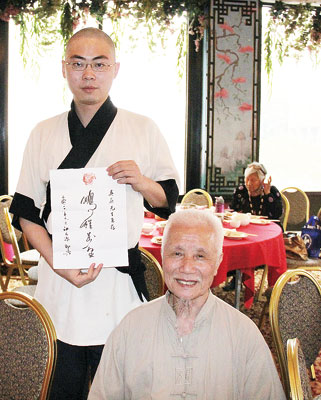 书画家江天源为吴蔚(左)题写「鹏程万里」表示祝贺。