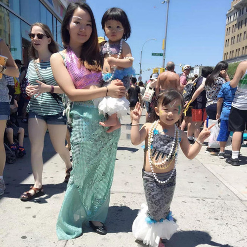 林韵桑(前左)帮女儿和侄女(右)打扮姐妹美人鱼装。(美国《世界日报》)