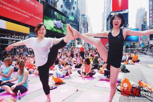 参与者金凯特与活动上结识的朋友一起展示高难度瑜伽动作。