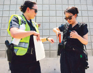 当地时间6月21日,洛杉矶市警局华裔警官豪瑟(左)教华文媒体记者使用手枪。(美国《侨报》/邱晨