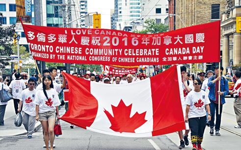 游行队伍持加拿大国旗。（加拿大《星岛日报》）