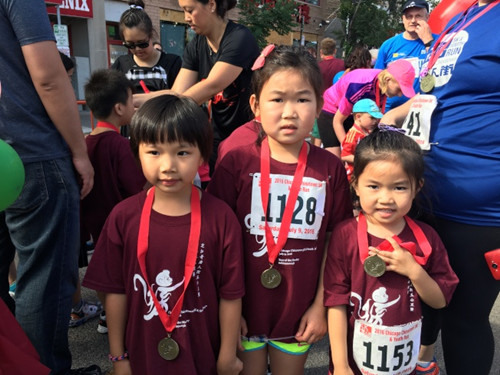 6到8岁儿童组的跑步赛后，可爱的小小运动员们，开心的展示完赛奖牌。(美国《世界日报》/黄惠玲