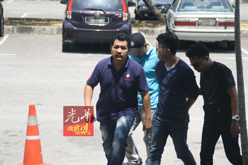嫌犯（右2）由3名警官押上法庭。（马来西亚《光华日报》）