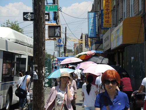 华裔民众出招对抗骄阳，缤纷的伞撑开8大道鲜有的伞海奇观。（美国《世界日报》/王靖雯