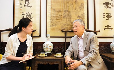 图为谢明(右)接受本报记者采访。