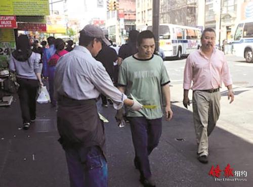 纽约法拉盛街头常有人发放华人补习班广告。(美国《侨报》图片)