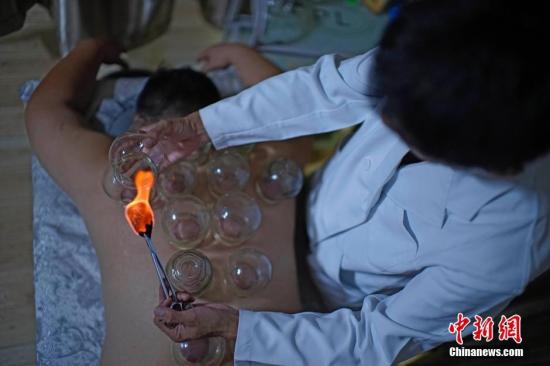 8月11日，天津，市民在一家中医推拿馆感受拔火罐。
