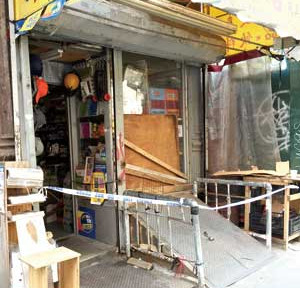 位于纽约爱烈治街的华人杂货铺遭窃后，警方封锁了现场。（美国《星岛日报》）