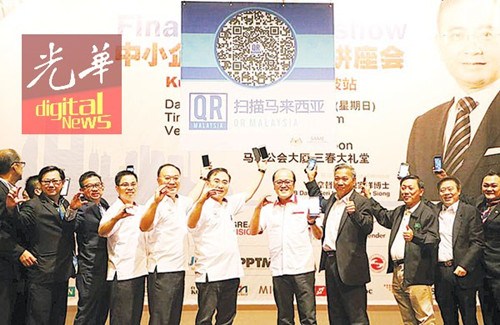 魏家祥(左5)等人推介中小型企业拓展中心二维码。(马来西亚《光华日报》)