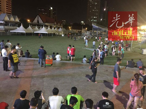 即将进入午夜,但仍有许多人聚集在独立广场捉精灵。(马来西亚《光华日报》)