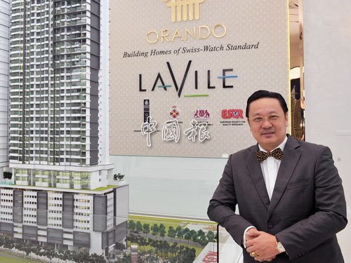 黄伟俊代表公司送出一间高级公寓给李宗伟。(马来西亚《中国报》)