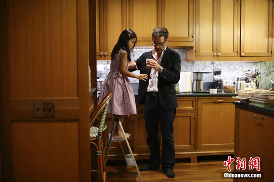 中国侨网图为爸爸搭梯子方便个子不够的维罗妮卡观看怎么制作巧克力奶。中新网记者 廖攀 摄
