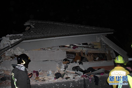 8月26日凌晨，在意大利阿马特里切，一名公羊会救援人员（右）和一名意大利消防员在坍塌的房屋前勘察。