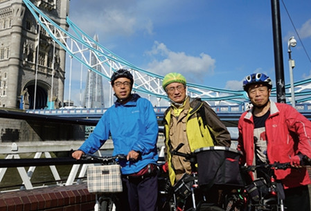 三位环英骑行勇士(左起)何润春、吴国富、马建设在伦敦塔桥前合影。(《欧洲时报》/受访者供图)