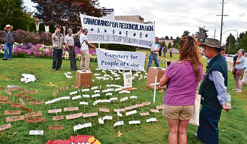 逾百个模拟不同族裔死者的纸牌墓碑与纸片，27日出现在二埠中学旁。（加拿大《星岛日报》）