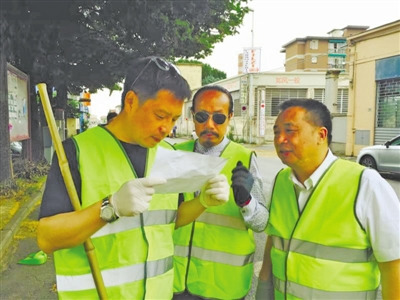 张力（左）与华侨志愿者义务打扫华人街。
