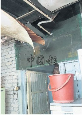 倾盆大雨一来,屋内处处都漏水,只好以水桶盛水。(图片来源:马来西亚《中国报》)
