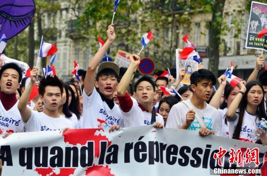 法国华社9月4日在巴黎市中心举行声势浩大的集会游行，悼念遇暴力抢劫被殴致死的旅法侨胞张朝林。来自法国社会各界的数万华侨华人共同发出“反暴力，要安全”的强烈呼声。图为参加游行的华人奋力发声。