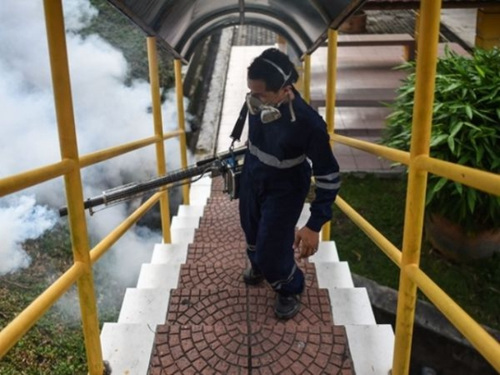 9月4日，马来西亚首都吉隆坡，一名工人在一所小学喷洒消毒液。(新华／法新)