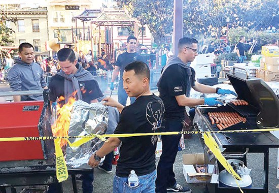 正在警察学校受训的新进警员于花园角替华埠安全夜的参加者烤肉。(记者李秀兰/摄影)