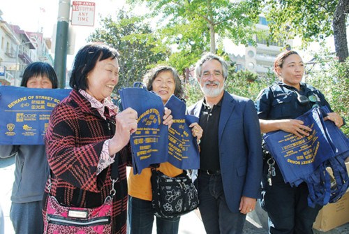 旧金山警局在华埠派发大量防金光党骗案环保袋，但调查进展缓慢，受害人失望。（美国《世界日报》/李秀兰