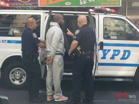 警方逮捕非裔男子并将其带上警车。（美国《侨报》）