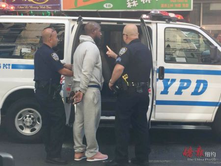 警方逮捕非裔男子并将其带上警车。(美国《侨报》)
