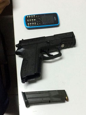 警方扣押嫌犯使用的警枪、弹匣及手机。(马来西亚《星洲日报》)
