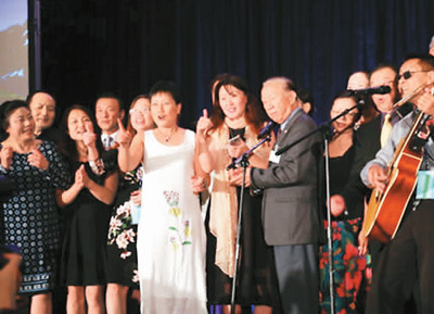 图为美国华人大会举办颁奖晚宴，各地华人上台齐唱歌。