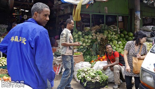 市场上摆放着面向中国人销售的蔬菜。埃塞俄比亚人身穿的上衣也印着中文。（日经中文网）