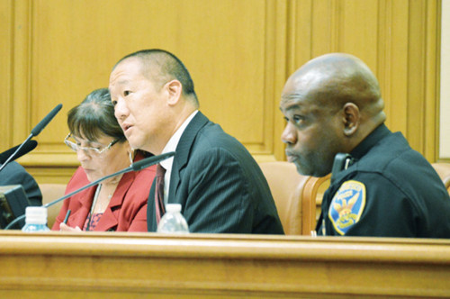 警察委员黄正凯(中)要求警局公布调查金光党骗案进展。对华人小区要求设立亚裔项目小组调查,代局长夏普林(右)不发一言。(美国《世界日报》/李秀兰