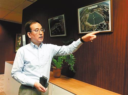 刁旭在办公室内向记者介绍上海电力日本株式会社的新能源项目建设情况。