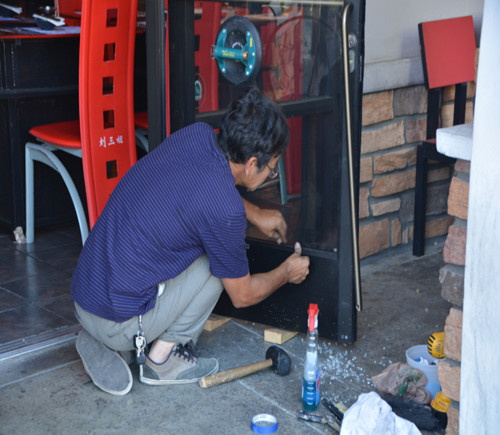火锅店门口26日上午正在更换被砸碎的玻璃。（美国《世界日报》/张宏