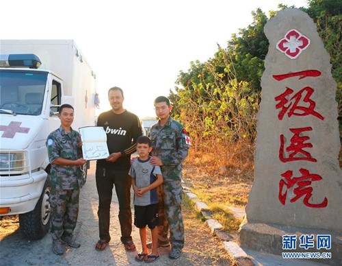 9月30日,在位于黎巴嫩南部辛尼亚村的中国第15批赴黎巴嫩维和多功能工兵分队设立的一级医院门口,烧伤痊愈的欧贝德·巴达维(左二)与院长杨涛(左一)和军医王阳(右一)合影。自中国维和部队2006年开始部署黎巴嫩南部以来,免费医疗援助行动已坚持了整整10年,累计救治当地村民近6万人次。由于医术精湛、服务热情,工兵分队一级医院逐渐声名远播,甚至远在首都贝鲁特的病人专程驱车近2个小时慕名赶来就诊。新华社发(华迅摄)
