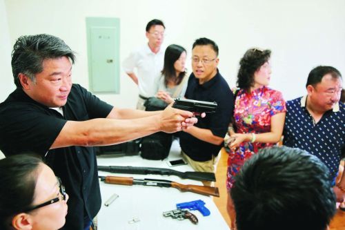 美国步枪协会教官刘大卫讲座后为部分听众示范如何使用手枪。（美国《侨报》/邱晨