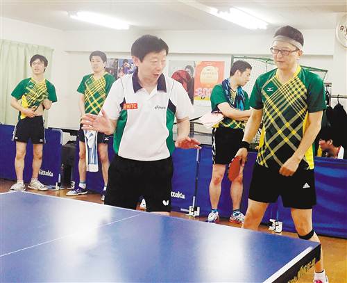 邓荻（左三）传授学员打乒乓球的技巧。