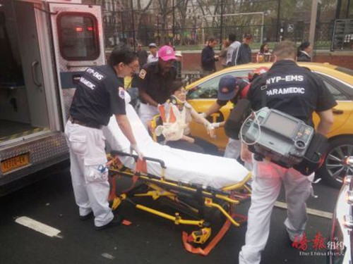 救护人员将受伤女子抬上救护车。（美国《侨报》/韩雨辰